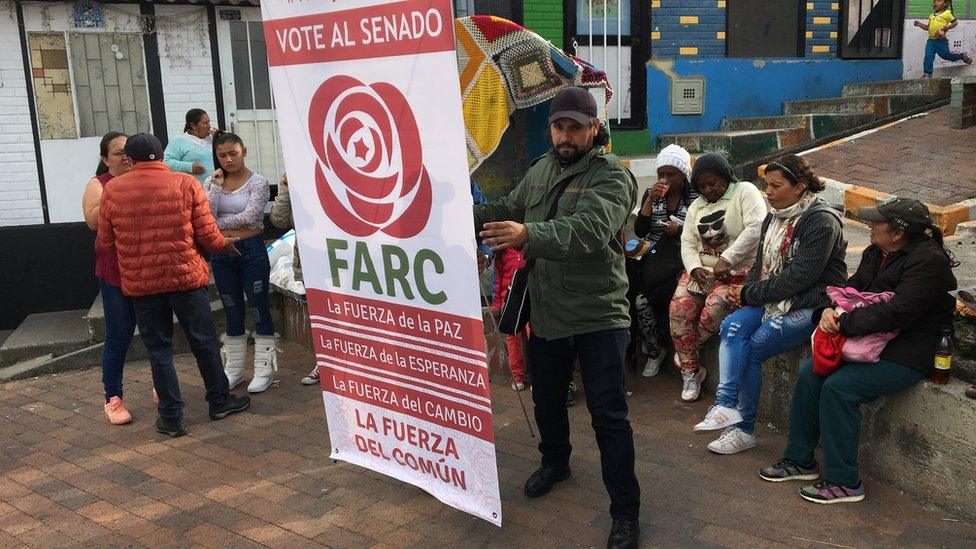 A man holds up a banner urging to vote for the Farc