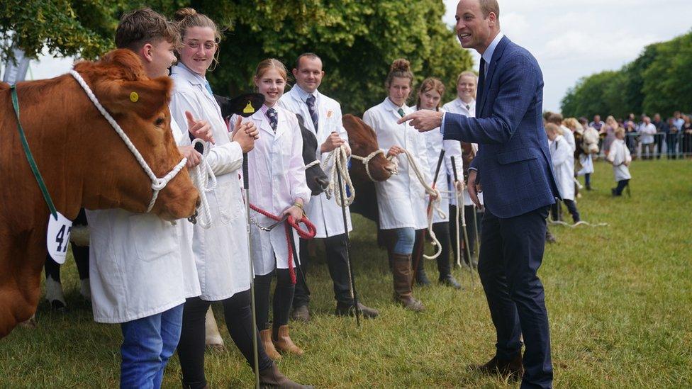 Prince William talks to young cattle handlers