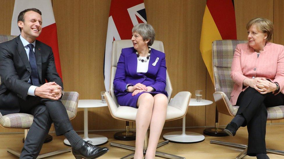 Emmanuel Macron, Theresa May, and Angela Merkel give a press conference following at the European Union leaders summit in Brussels on 22 March