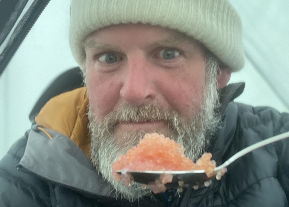 Mike Keen eating in his tent in Greenland