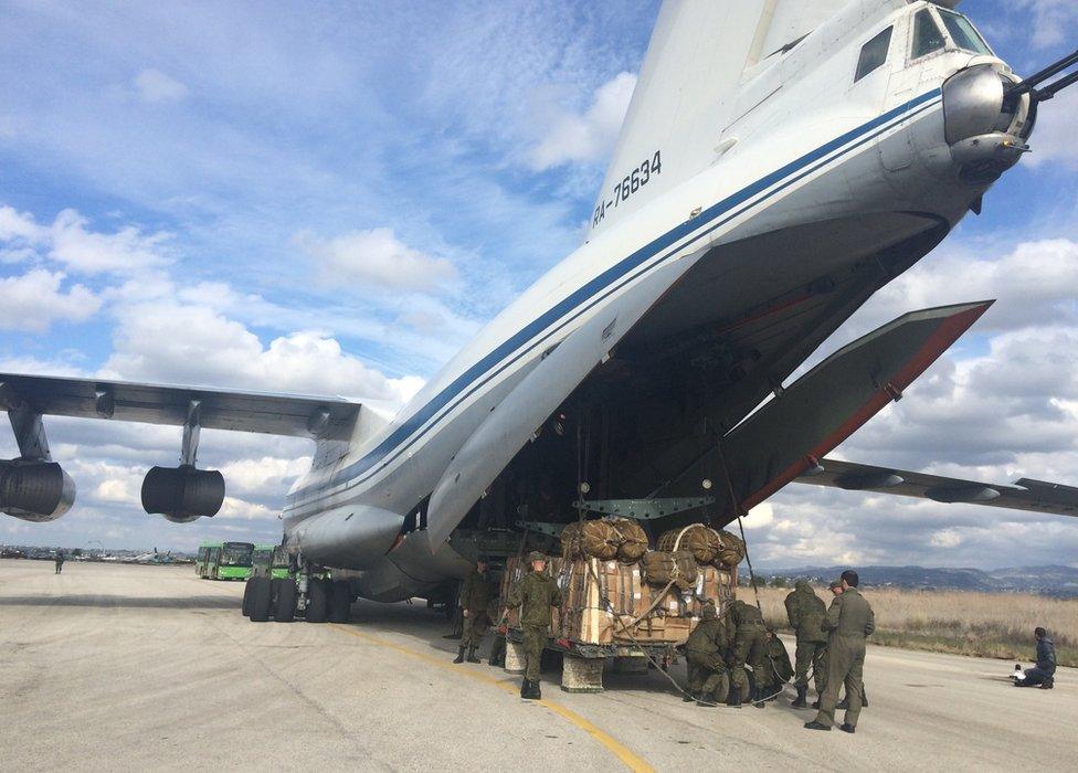 Military personnel load up a jet