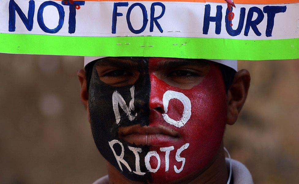 An Indian student with a peace message painted on his face attends a peace rally on the 65th death anniversary of India's father of the nation Mohandas Karamchand Gandhi