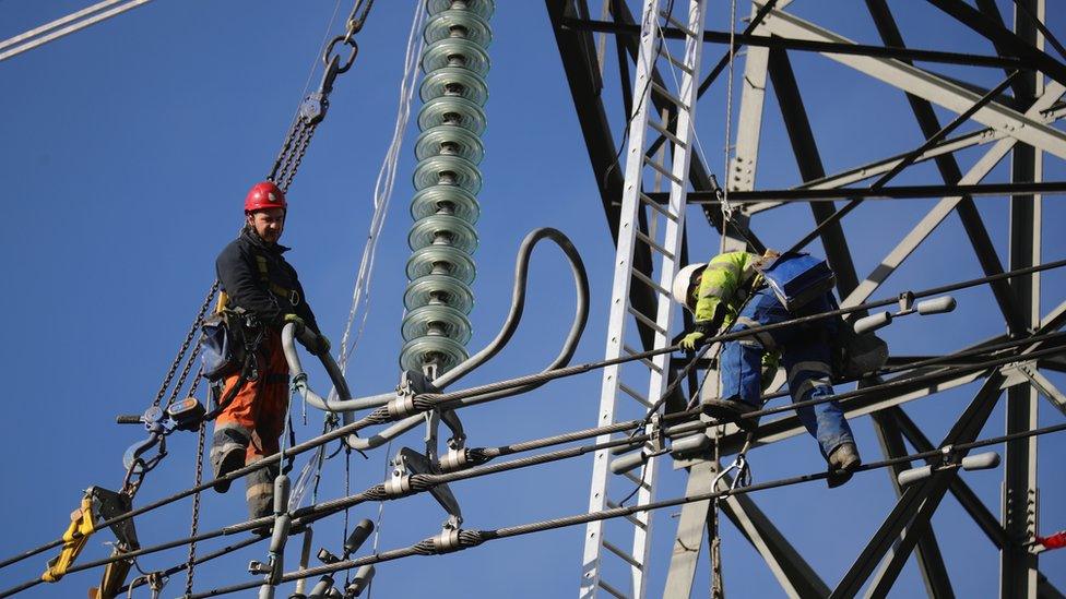 workers repairing electricity pylon