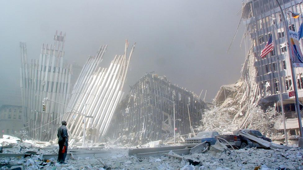 A man stands in the rubble after the collapse of the first World Trade Center Tower