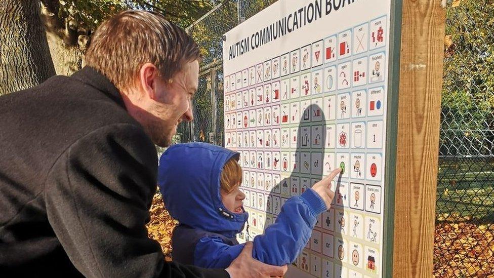 Father and son pointing at the picture communication board