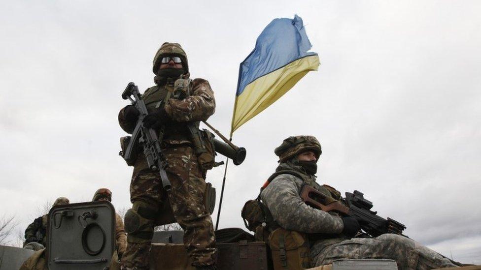 Ukrainian servicemen ride on an armored personnel carrier (APC) at a checkpoint near the eastern Ukrainian town of Debaltseve in Donetsk region (24 December 2014)