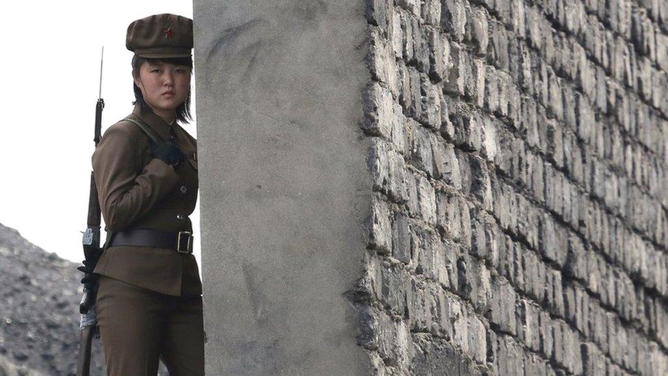 A North Korea woman soldier patrols the bank of the Yalu River which separates the North Korean town of Sinuiju from the Chinese border town of Dandong