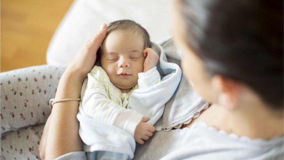 Mother looking her newborn child - stock photo