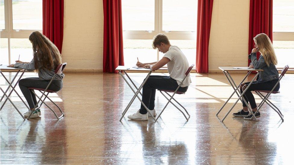 Three children in an exam hall