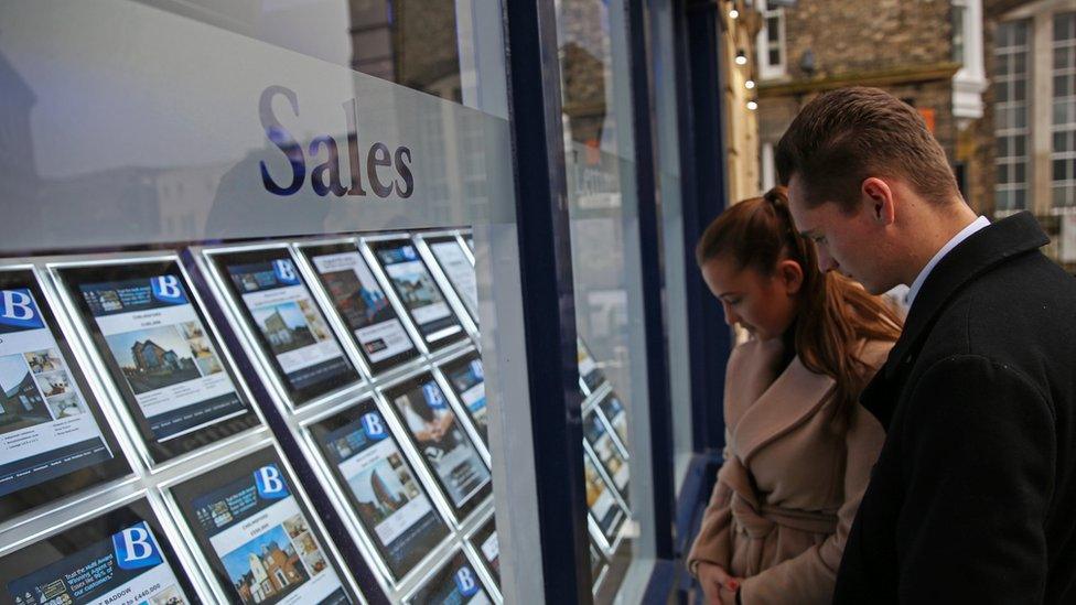 couple looking in estate agent window