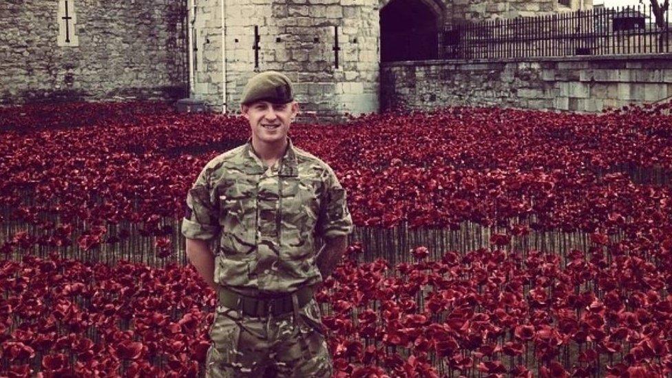 Craig in uniform stood amongst poppies