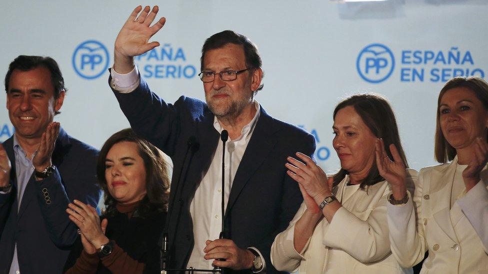 Spain"s Prime Minister and People"s Party (PP) candidate Mariano Rajoy waves to supporters from a balcony at the party headquarters