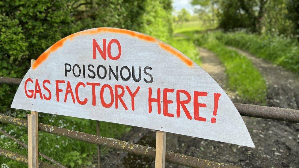 Banner saying 'no poisonous gas factory here"