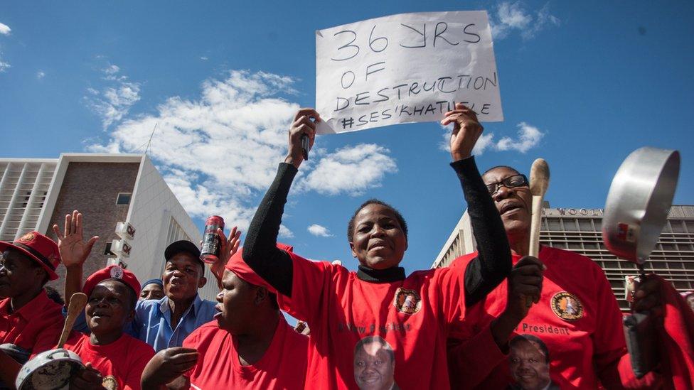 A woman holds a placard referring to the 36 years of rule by President Robert Mugabe during a demonstration on 16 July 2016 in Bulawayo