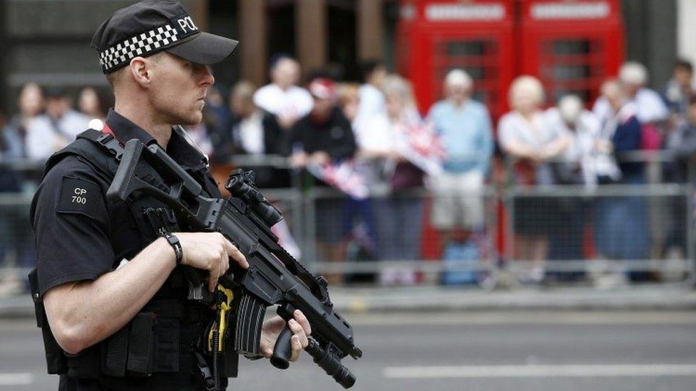 Armed police officer patrols ahead of a service of thanksgiving for Queen Elizabeth"s 90th birthday in London