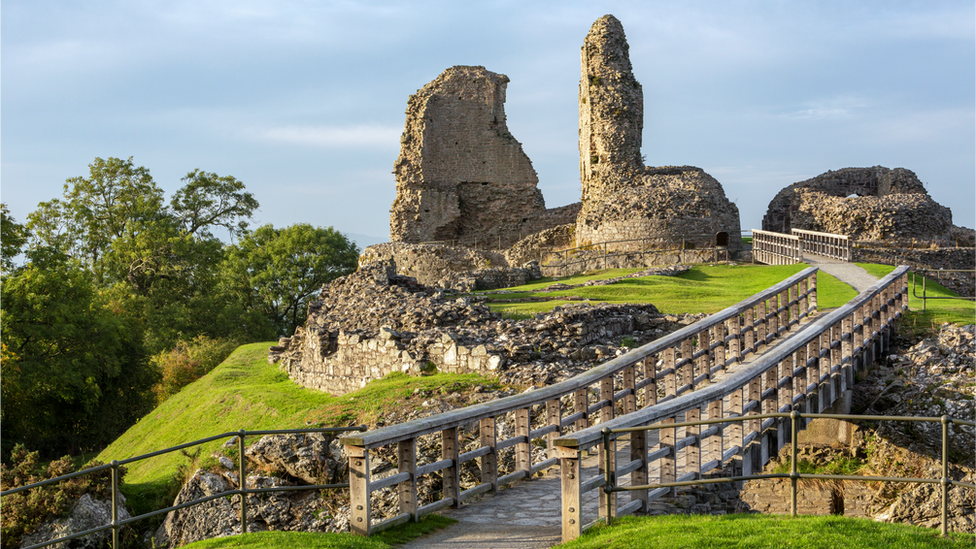 A still of the ruins of Montgomery Castle on a sunny day with the bridge at to the castle at the front