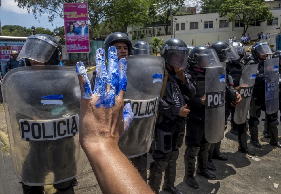 Nicaraguan women protest in front of riot police during a demonstration in Managua on 2 May 2018