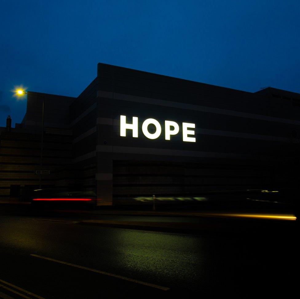 An image of a dark sky and a large sign that says Hope