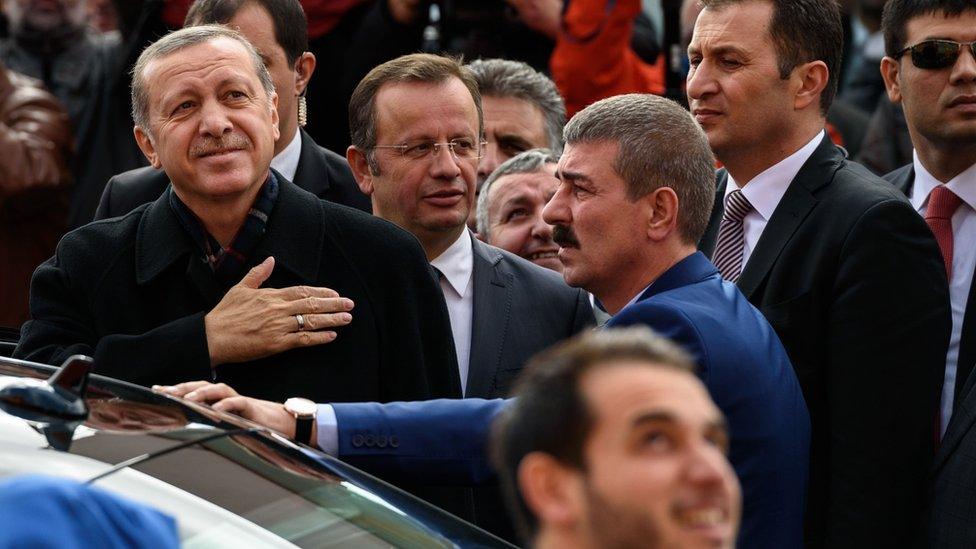 Turkish President Recep Tayyip Erdogan (L) gestures to supporters after voting in parliamentary elections in Istanbul on 1 November 2015