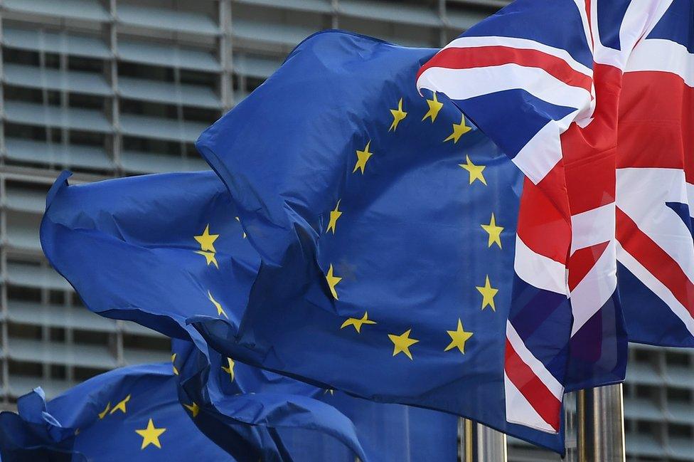 A Union Jack flies next to European Union flags in front of the European Commission, 16 October 2017