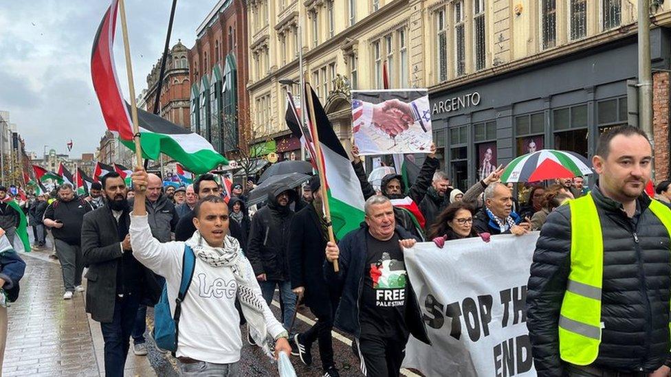 protestors with flags and signs in Belfast city centre