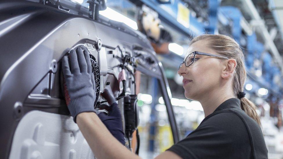 Young worker in car manufacturing production line