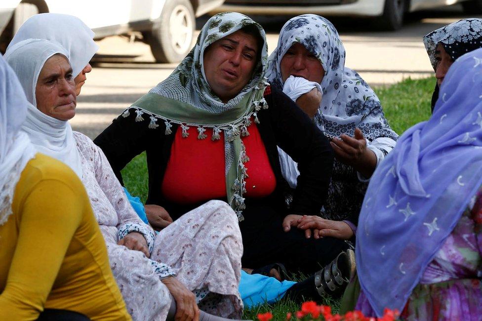 Women wait outside a morgue in the Turkish city of Gaziantep, 21 August