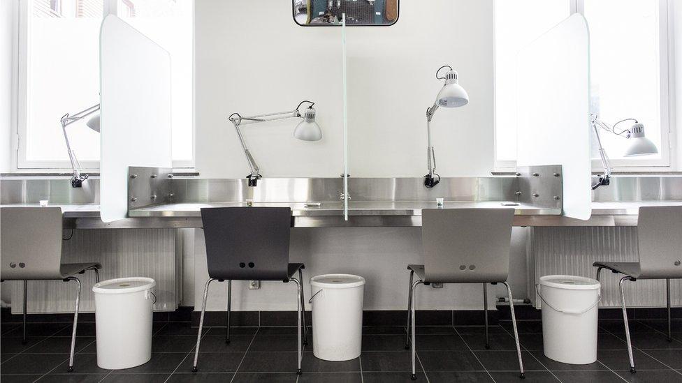 A long table and chairs in a drug consumption clinic