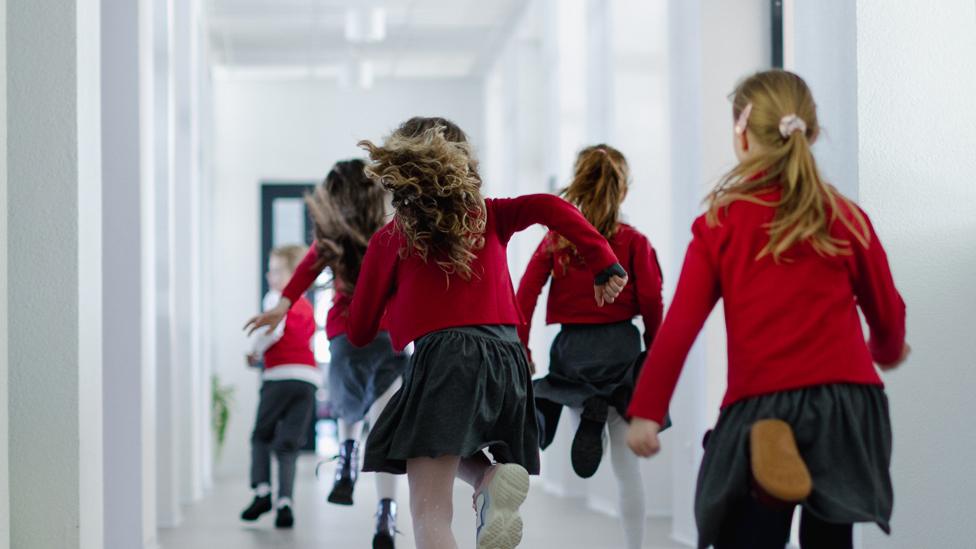 Children running down a school corridor