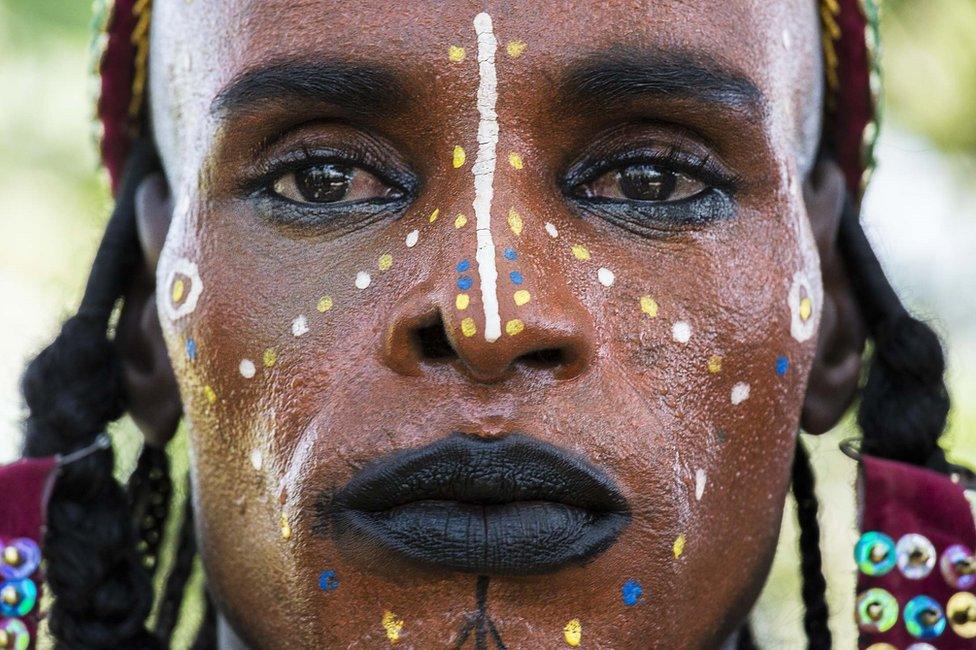 Man’s face made up with lipstick and eyeliner