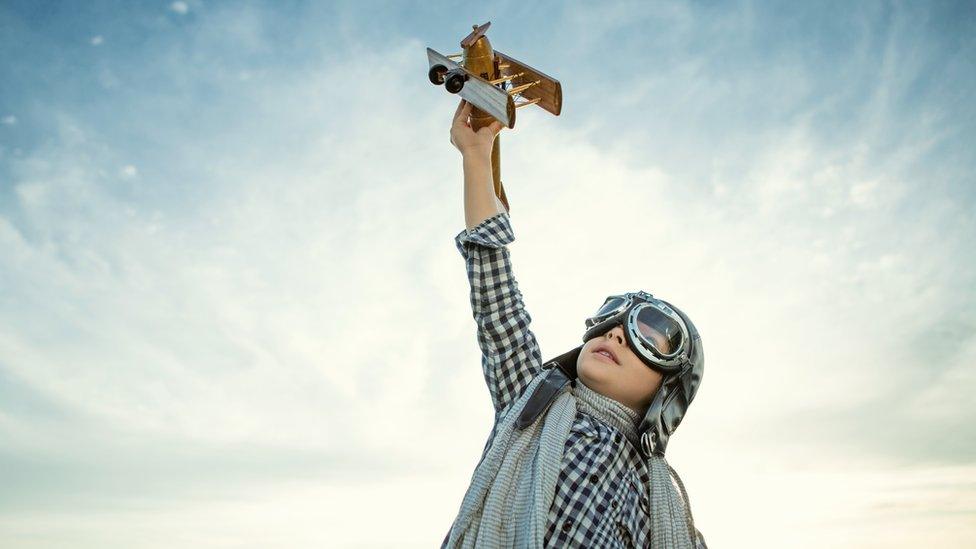 A kid flying a toy plane