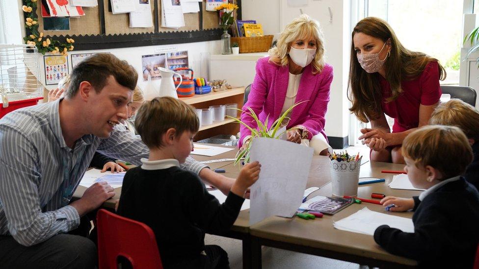 The duchess and First Lady wear masks as they sit round a table with children