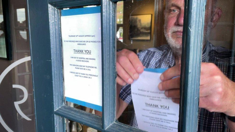 Julian Penge putting posters in the pub