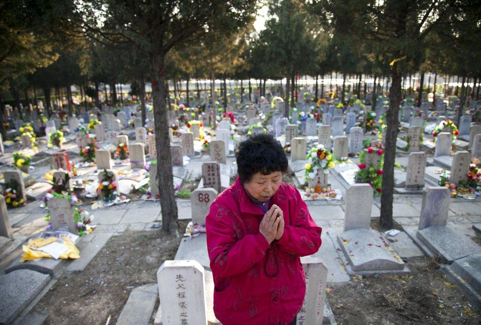 This photo taken on 4 April 2011 shows a Chinese woman praying at the grave of a loved one at the Babaoshan cemetery in Beijing to mark 'Qing Ming' or Tomb Sweeping Da