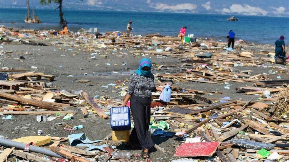 A survivor salvages useable items from debris in Palu, Indonesia's Central Sulawesi on October 1, 2018, after an earthquake and tsunami hit the area on September 28.