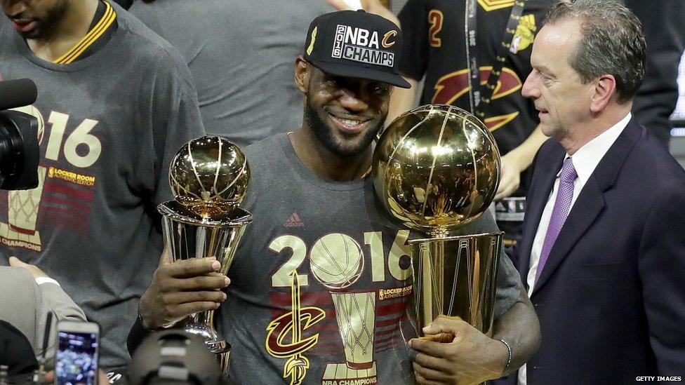 Lebron James holding two trophies