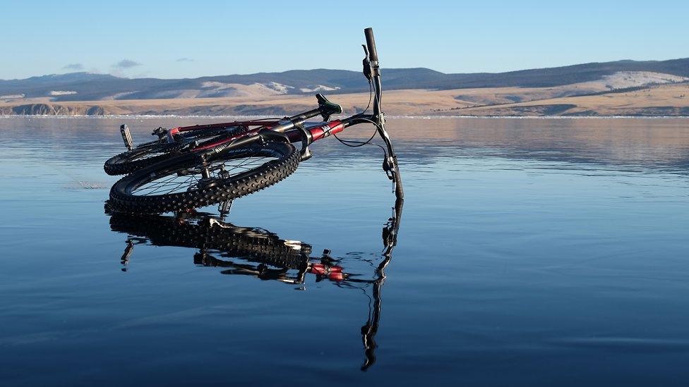 An abandoned bike lying on the frozen lake