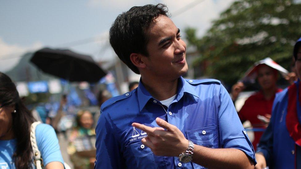 Norashman (C), the son of Malaysia's Prime Minister Najib Razak of ruling party National Front, walks with his sister Nurul Najwa (L) as his father campaigns ahead of the 13th general election in Kuala Lumpur on 22 April 2013.