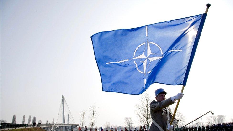 Soldier carrying a Nato flag