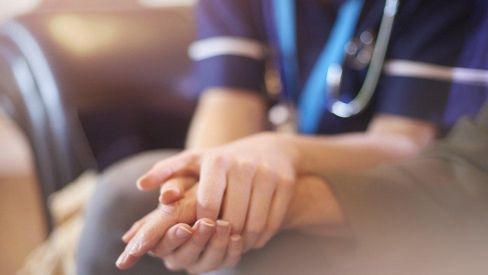 A nurse comforting a patient