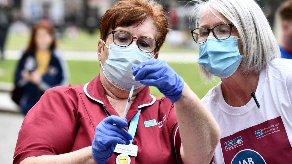 Medical professionals prepare a vaccine at a walk-in Covid-19 vaccination clinic at Belfast City Hall