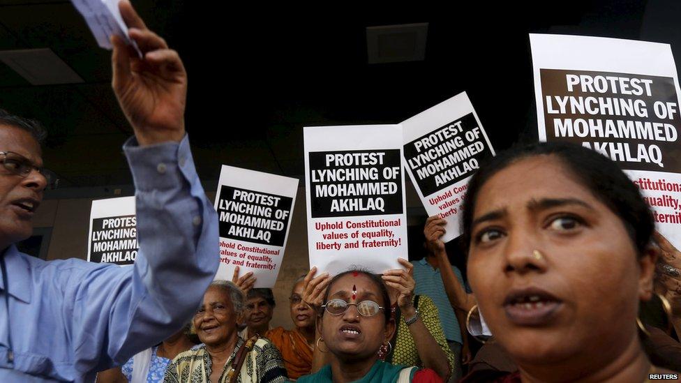 Protestors hold up slogans against the killing of a Muslim man