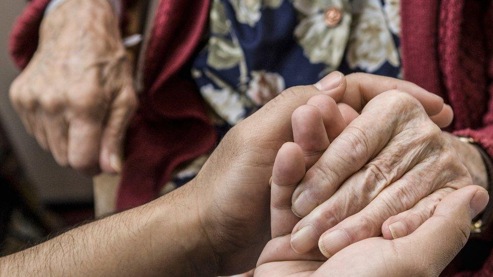 Someone holding the hands of an elderly person, stock image