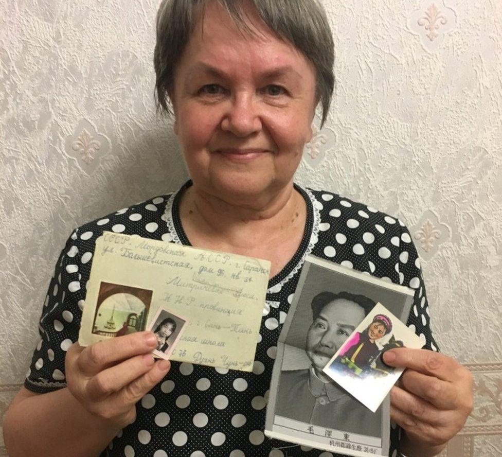 Lyudmila Mitricheva, holding up a letter written in Russian and a photo of her Chinese pen pal