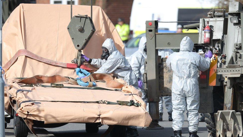 Soldiers wearing protective clothing prepare to lift and recover an Ashley Wood recovery vehicle in Hyde Road, Gillingham, Dorset