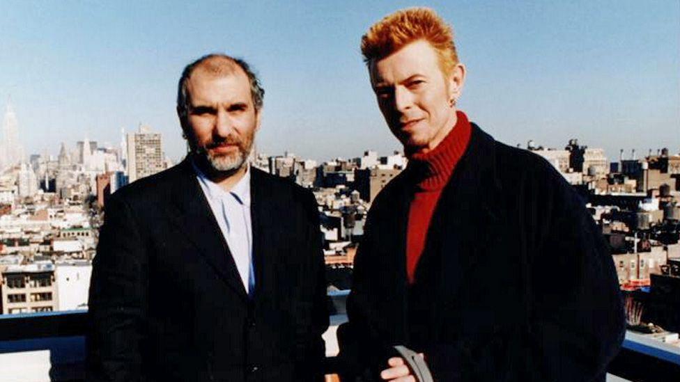 Changes: Bowie At Fifty - Picture shows Alan Yentob (left) and David Bowie. Yentob. The pair, both wearing black suits, are pictured with the London skyline behind them.