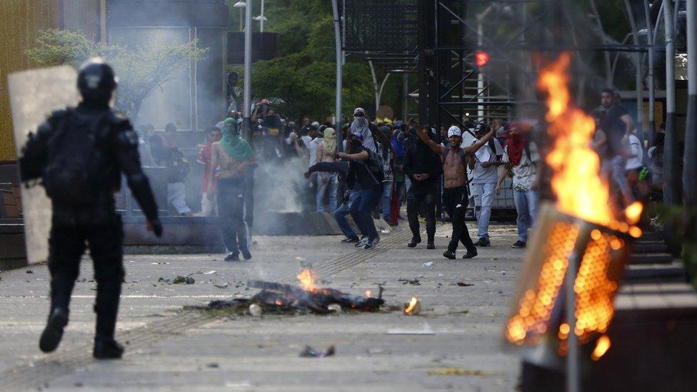 Members of the police and protesters clash during in Cali