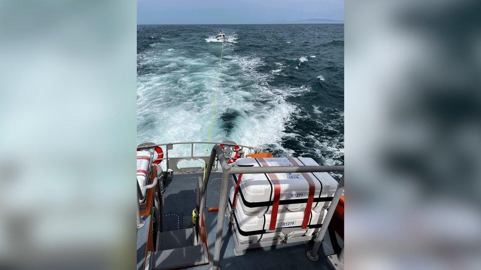 The boat being towed to shore