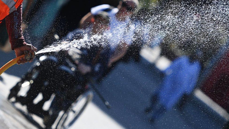 A person spraying a hosepipe