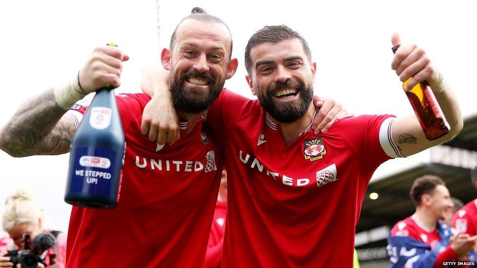 Chwaraewyr Wrecsam Steven Fletcher ac Elliot Lee yn dathlu dyrchafiad